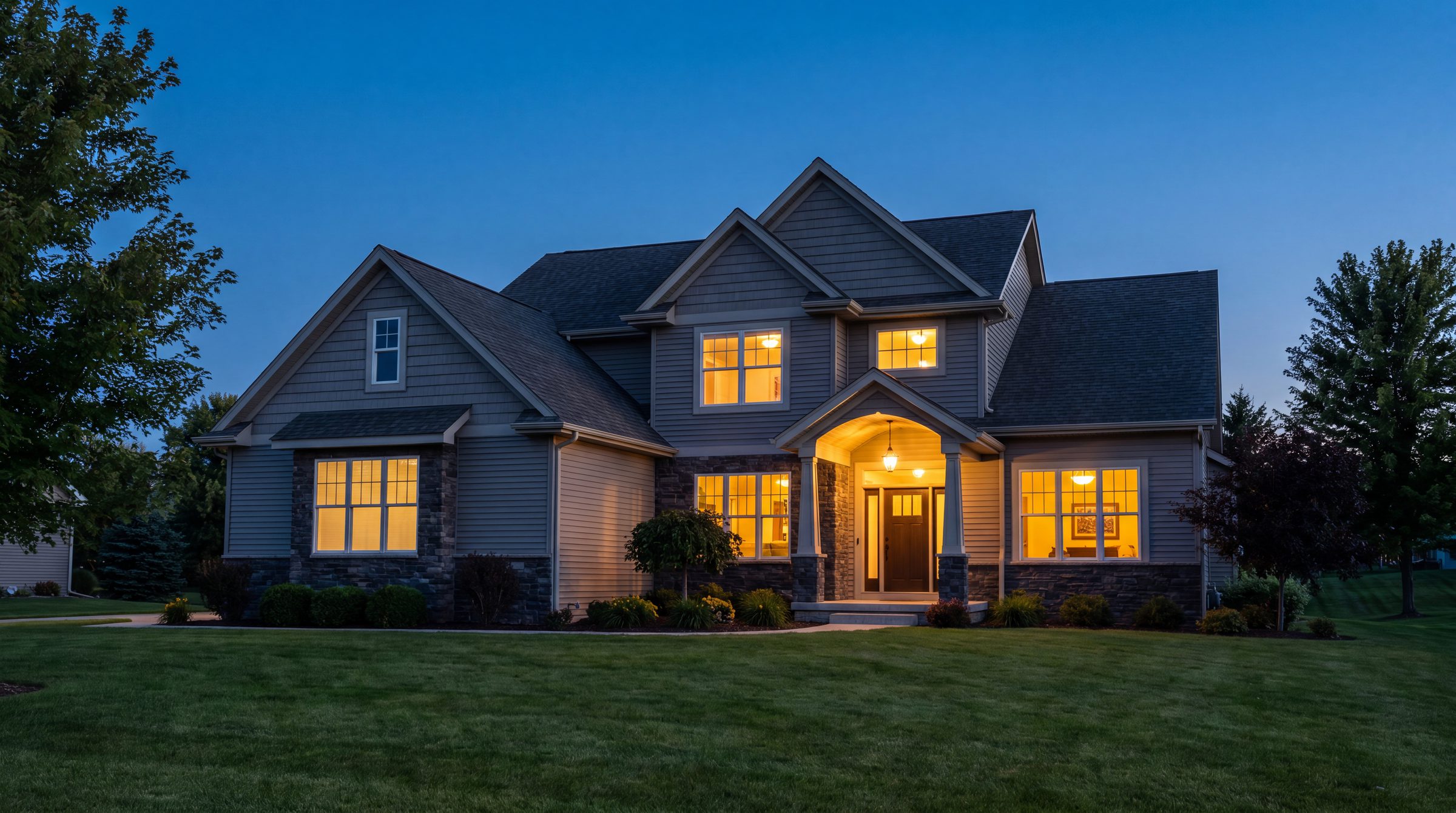 A handsome DFW home glowing warmly at dusk after a Chariot exterior renovation